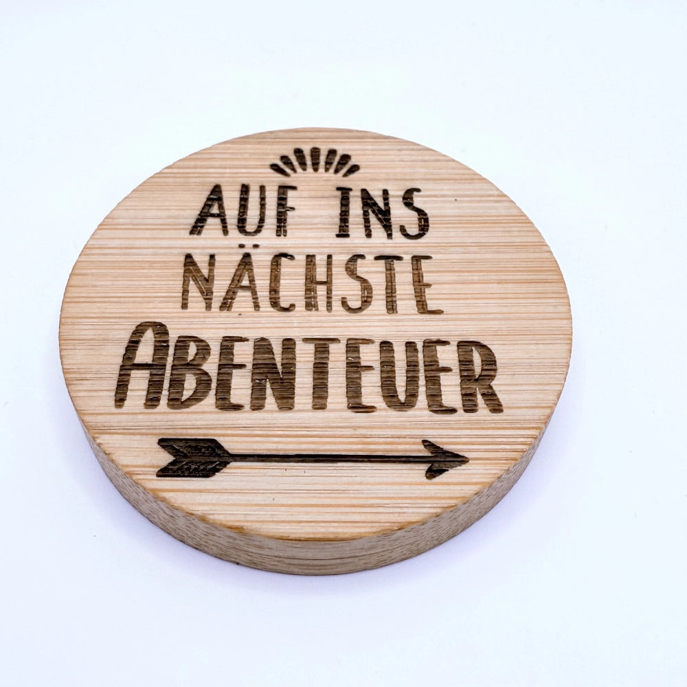 Runder Flaschenöffner-Magnet aus Bambus mit Gravur "Auf ins nächste Abenteuer".