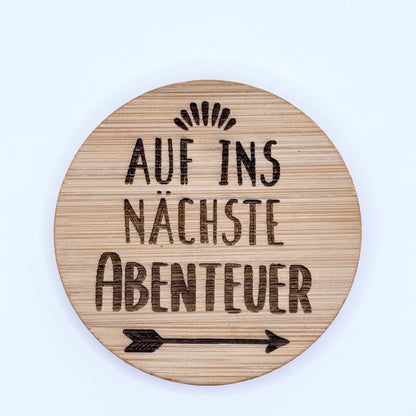 Runder Flaschenöffner-Magnet aus Bambus mit Gravur "Auf ins nächste Abenteuer".