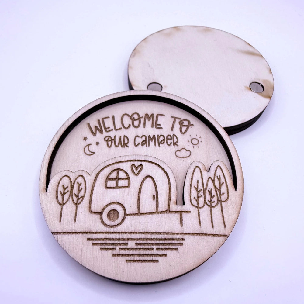 Runder, gravierter und per Laser-geschnittener Holzmagnet in zwei Schichten, mit Campingmotiv "Welcome to our Camper". Hier mit Rückseite, auf der 2 Magnete zu sehen sind.