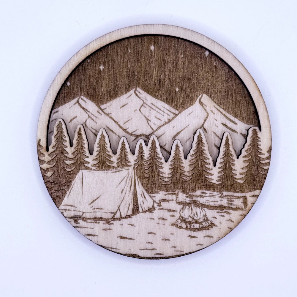 Runder, gravierter und per Laser-geschnittener Holzmagnet in zwei Schichten, mit Campingmotiv "Wald und Berge".