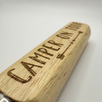 Flaschenöffner aus Holz und Metall mit Aufschrift „Camper on Tour“.