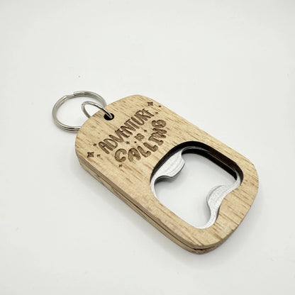 Ein hölzerner Flaschenöffner-Schlüsselanhänger mit der Aufschrift "Adventure is Calling".