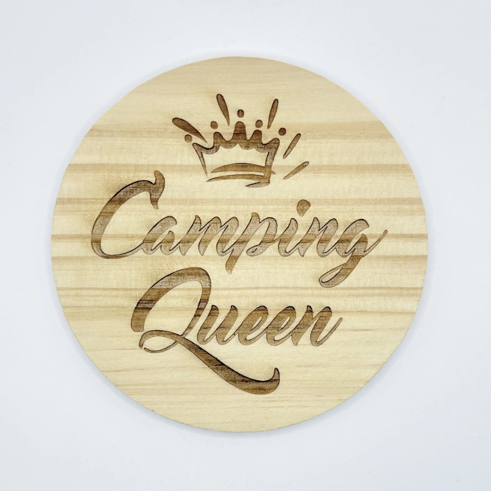 Runder Holzuntersetzer mit dem Aufdruck "Camping Queen" und einer Krone.