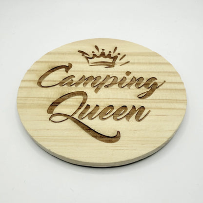 Runder Holzuntersetzer mit dem Aufdruck "Camping Queen" und einer Krone.