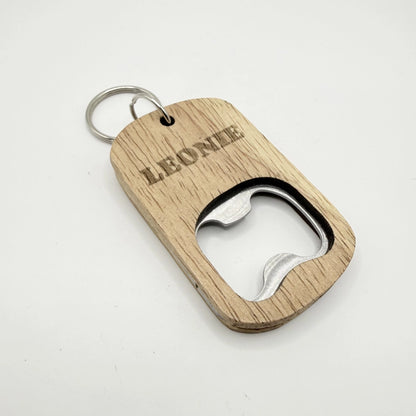 Ein hölzerner Flaschenöffner-Schlüsselanhänger mit der Aufschrift "Adventure is Calling".