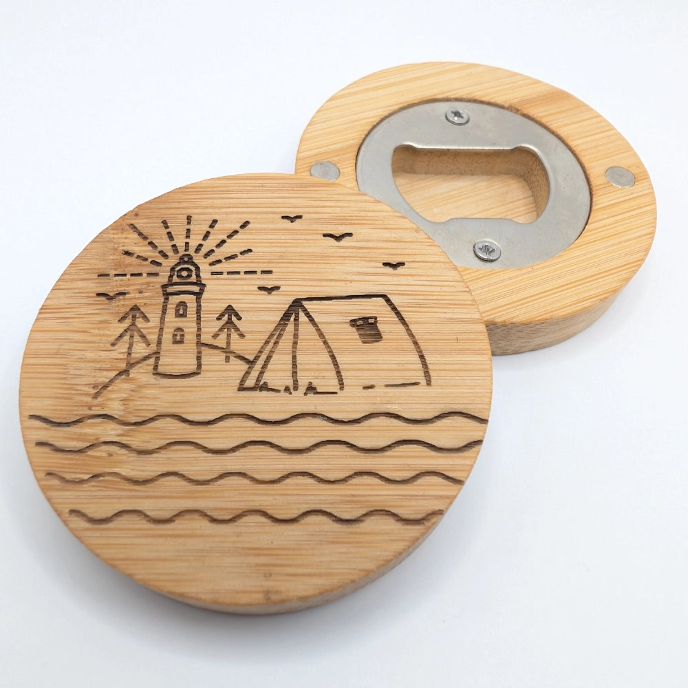 Runder Kühlschrankmagnet mit integriertem Flaschenöffner aus Bambusholz, mit einer Gravur versehen, bestehend aus einem Leuchtturm und einem Zelt.